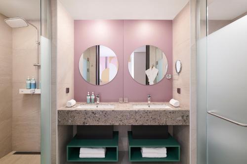 仁川市ibis Styles Ambassador Incheon Airport T2的浴室设有2个水槽和2面镜子