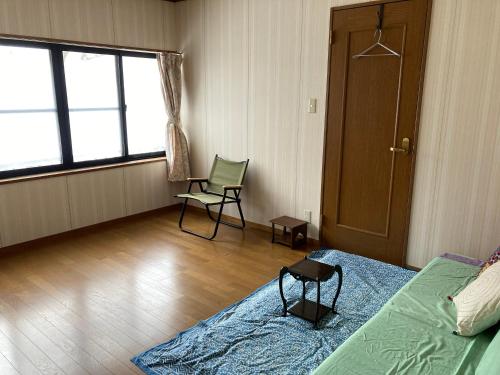 长野Breath in Earth的卧室配有床、椅子和窗户。