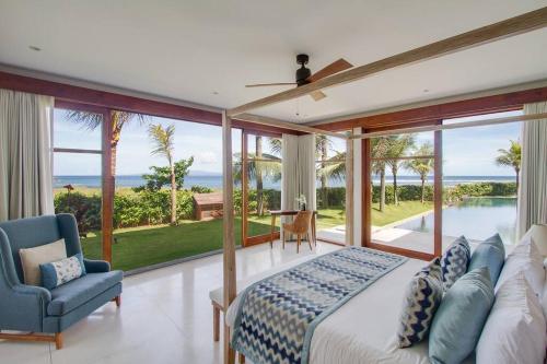 KetewelBeachfront Luxury, Villa Purnama的一间卧室配有一张床,享有海景