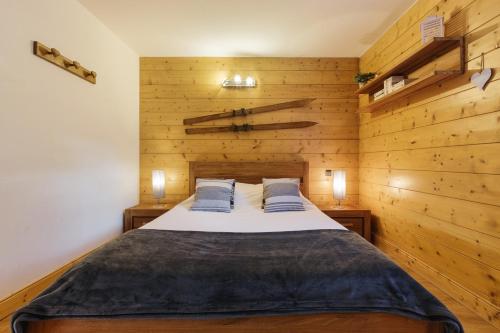 Le TourAppt Bec A2 - Happy Rentals的一间卧室配有一张带木墙的大床