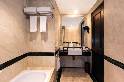 名古屋AP Premier Batam的带浴缸、水槽和镜子的浴室