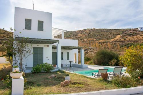斯基罗斯岛Superior Villa Lino的白色的房子,后面设有游泳池和山脉