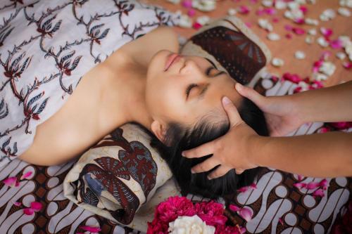 婆罗浮屠婆罗浮屠度假村别墅的女人躺在床上闭上眼睛