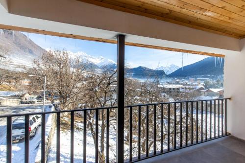 梅斯蒂亚Mestia Hotel Amirani的客房设有阳台,享有雪覆盖的山脉美景。