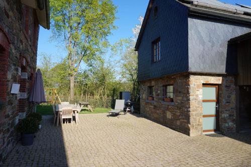 韦姆Le Walkoti - cosy cottage with 2 bedrooms的砖砌建筑,设有配备桌椅的庭院
