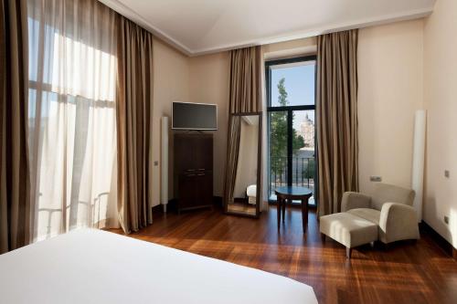 阿兰约兹帕拉西奥亚兰珠斯NH精选酒店的酒店的客房 - 带一张床、椅子和窗户