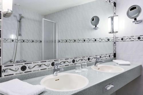 阿纳姆阿纳姆莱克NH酒店的一间带两个盥洗盆和大镜子的浴室