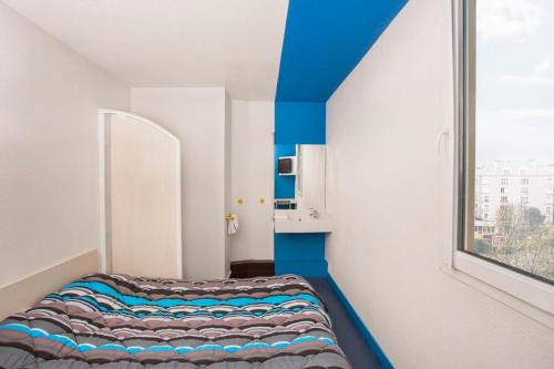科尔马hotelF1 Colmar Parc des Expositions的带窗户的客房内的一张床