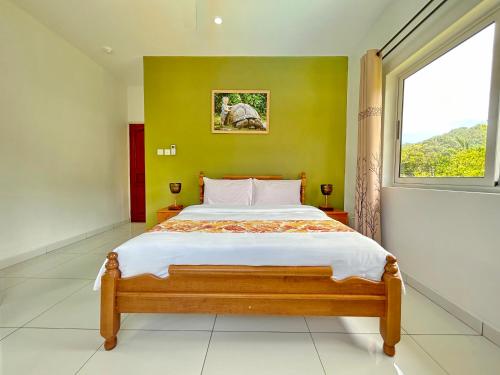 马埃岛The Seaboards Apartments Seychelles的一间卧室设有一张大床和窗户
