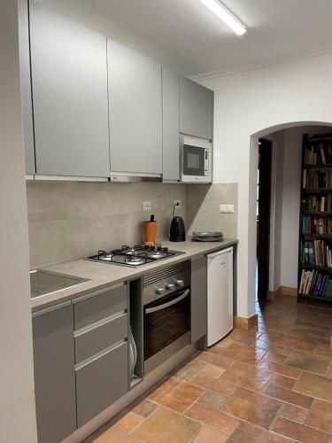 塔维拉Fazendinha - Tavira - Spacious and tranquil的厨房配有白色橱柜和炉灶烤箱。