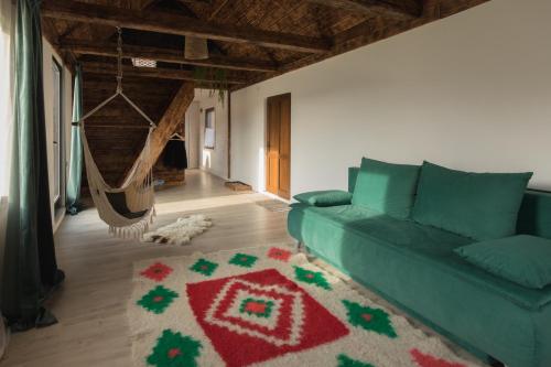 SîncrăieniOrganicle Lodge的客厅配有绿色沙发和地毯。