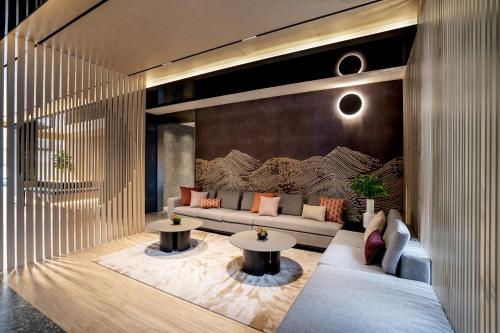 北京base佰舍服务式公寓（北京三里屯工体店）的客厅配有沙发和2张桌子