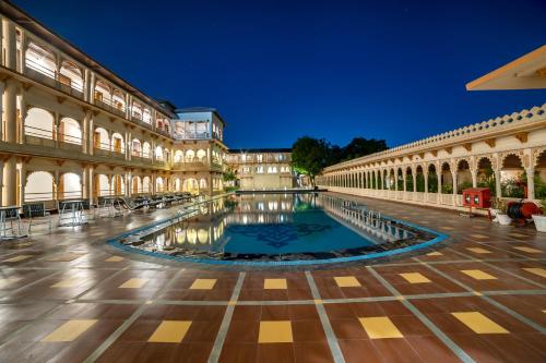 甘德希罕Holiday Resort & Spa A Unit of S Poddar Group的一座建筑中间带游泳池的庭院