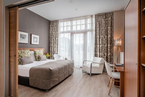 克勒伊斯贝尔亨Hotel De Pupiter的一间卧室配有一张床、一张书桌和一个窗户。