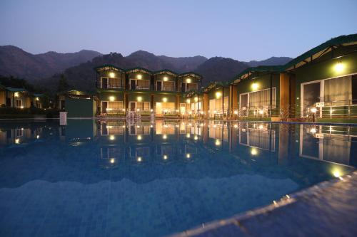 瑞诗凯诗Camp Brook - Luxury Camping in Rishikesh的夜间设有游泳池的酒店