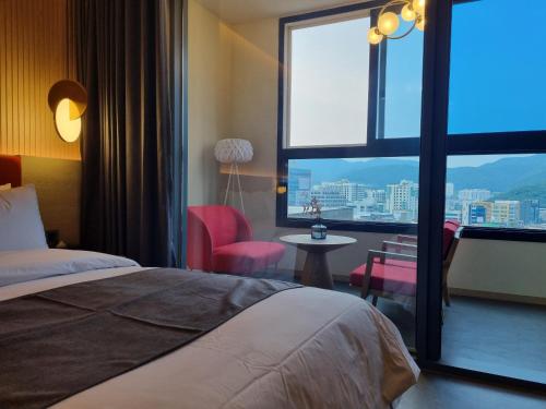 釜山Hound Hotel Junggwan的酒店客房设有一张床和一个大窗户
