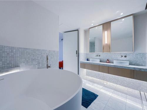 悉尼Pyrmont Town House Homestay的白色的浴室设有2个盥洗盆和1个浴缸。