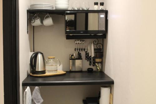 乔治9 Serendipity Stay的厨房配有黑架和微波炉