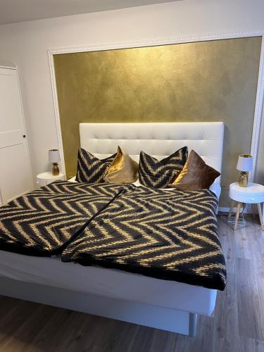 皮尔纳Appartement im Funkenhöfchen的一张配有黑白床单和金色枕头的床