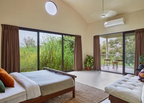 罗纳瓦拉SaffronStays Yahvi Waters by Kosha Villas, Pawna - pool villa with stunning lake view的一间卧室设有一张床和一个大窗户
