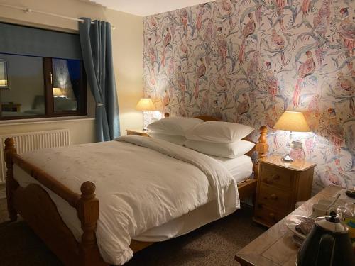 科比Laundimer House的一间卧室配有一张带花卉壁纸的床