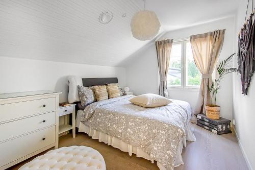 NummelaVilla Björkbacken的一间卧室配有一张床、一个梳妆台和一扇窗户。