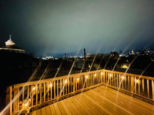巴尔的摩Cozy home with rooftop deck-downtown baltimore的木板路,晚上有灯