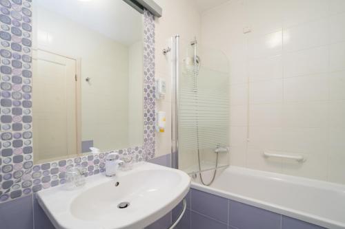 乌马格酒兹拉特娜瓦拉酒店的白色的浴室设有水槽、浴缸和淋浴。