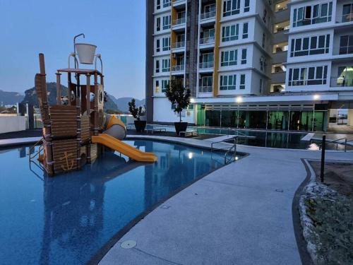 怡保Ipoh D'Festivo Luxury Homestay的一座大楼内带游乐场的游泳池