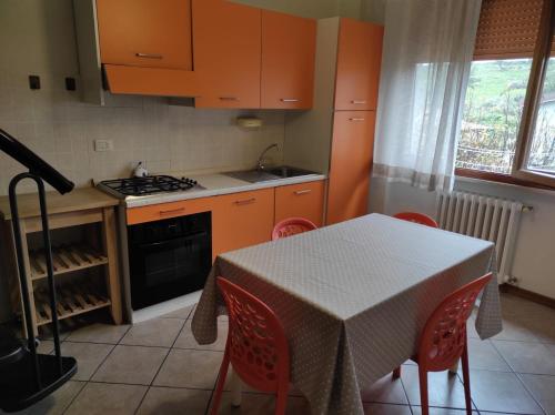 博尔格阿布贾诺Casina di mezzo的厨房配有橙色橱柜和桌椅