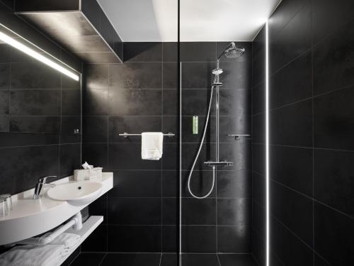 斯帕Le 24 Hotel的带淋浴和盥洗盆的黑色浴室