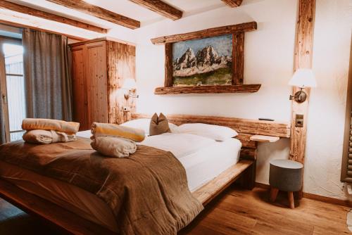 卢松贝格斯劳斯酒店的卧室配有一张床,墙上挂有绘画作品