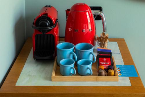 第比利斯Khedi Hotel by Ginza Project的茶壶,桌子上装有蓝色杯子的托盘