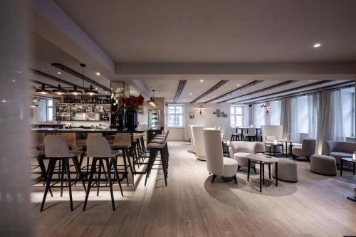 丁克尔斯比尔HOTEL & SPA Goldene Rose的一间设有酒吧的房间,并提供一些桌椅