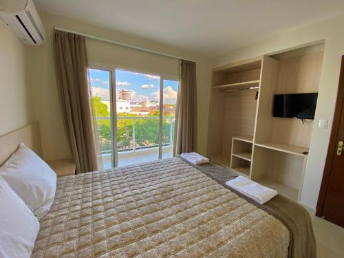 伊瓜苏Residencial Shalfa的一间卧室设有一张床和一个大窗户