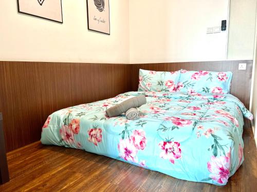努沙再也Teega Suites Puteri Harbour Iskandar Puteri #PoolView SeaView的一张带蓝色棉被和粉红色花卉的床