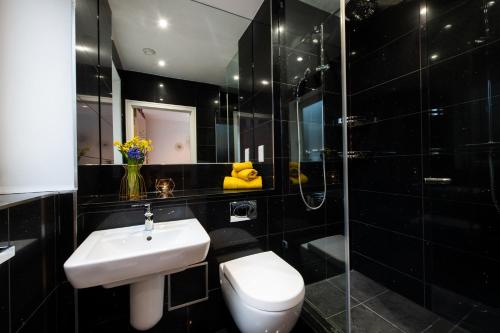 伦敦London Nino Apartments的浴室配有卫生间、盥洗盆和淋浴。