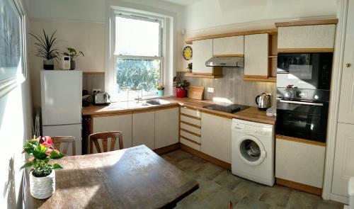 伦敦1 Bed flat in East Dulwich的厨房配有桌子、水槽和洗碗机。
