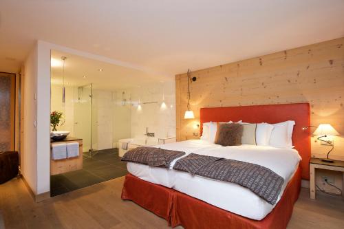 采尔马特Matterhorn Lodge Boutique Hotel & Apartments的一间带大床的卧室和一间浴室