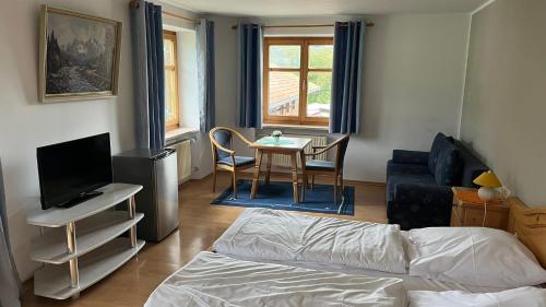阿尔高内的伊门施塔特Landgasthof Jägerhaus的客厅配有床和桌椅