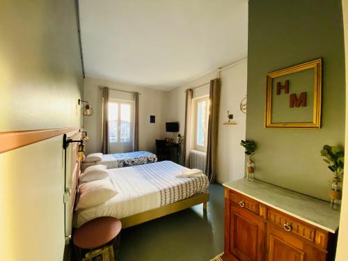 奥弗涅库尔农Hotel Le Midi Clermont-Cournon的一间设有两张床的卧室,位于带绿色墙壁的房间