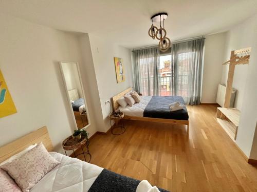 萨拉戈萨Apartamento Vive Zaragoza IV的一间卧室设有两张床和大窗户