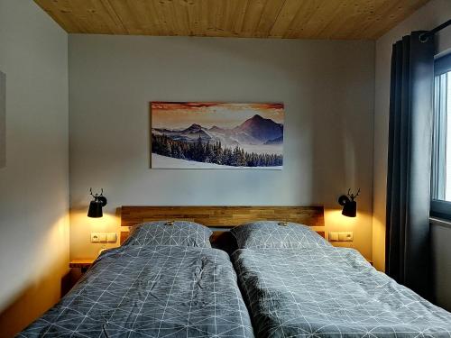 VorderhornbachHoamatgfühl的卧室配有两张床,墙上挂着一幅画