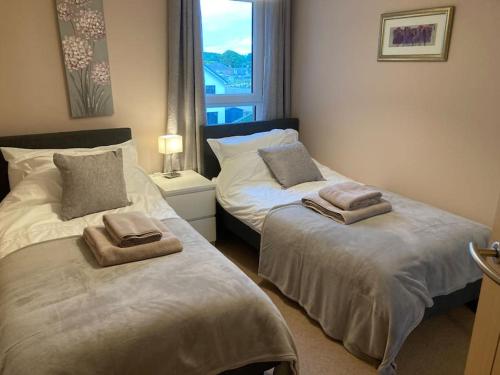 卡诺斯蒂Beautiful 2 bedroom flat overlooking golf course的一间卧室配有两张带毛巾的床