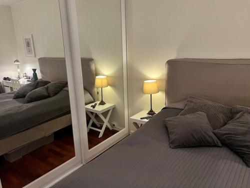 奥斯陆Oslo City Apartment的一间卧室设有两张床和大镜子
