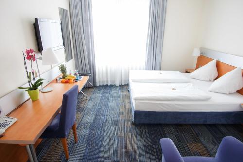美因河畔法兰克福塞内特酒店的配有一张床和一张书桌的酒店客房