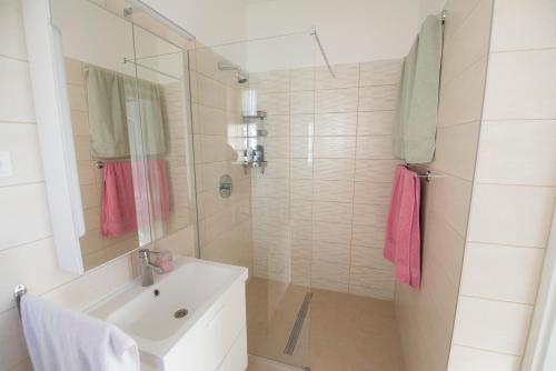 蒂萨新城K33的浴室配有水槽、淋浴和粉红色毛巾