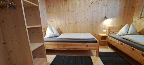 萨尔巴赫Chalet Ablon的木房内设有两张床的房间