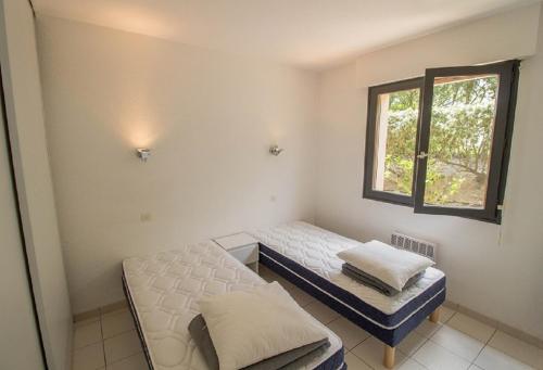 米尼赞海滩L'embarcadère的客房设有两张床和窗户。