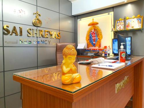 班加罗尔Sai Shreyas Residency, Best Hotel near Bangalore Airport的坐在办公室桌子上的黄雕